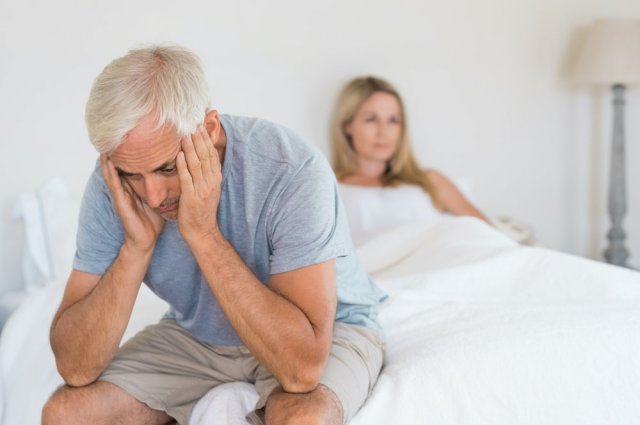 Mann sitzt verzweifelt auf Bettkante - Symbolbild für Impotenz nach einer Prostata Operation